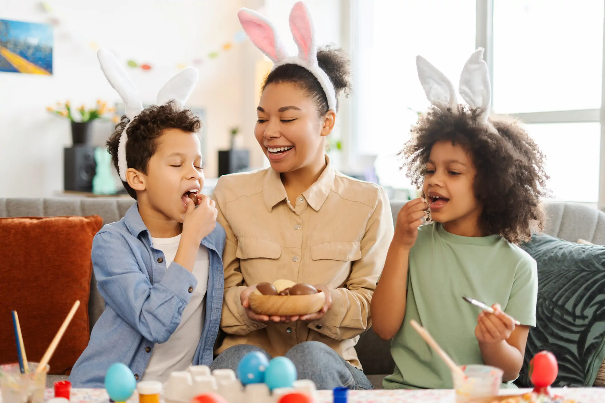 Kids eating chocolate easter eggs with mum.