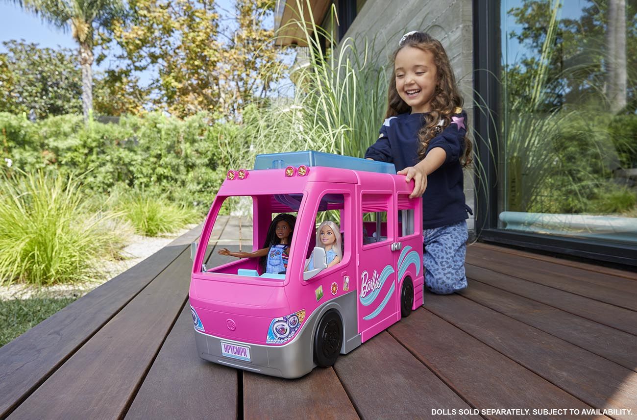 Child plays with Barbie's camper.