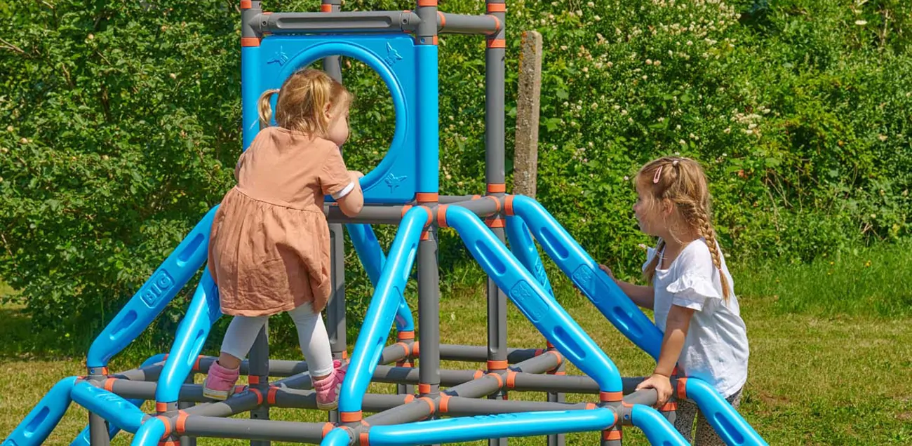 2 children playing on a climbing frame