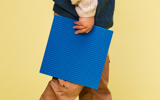 Boy holding a blue LEGO baseplate