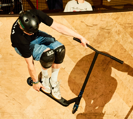 Boy showing off tricks on a stunt scooter