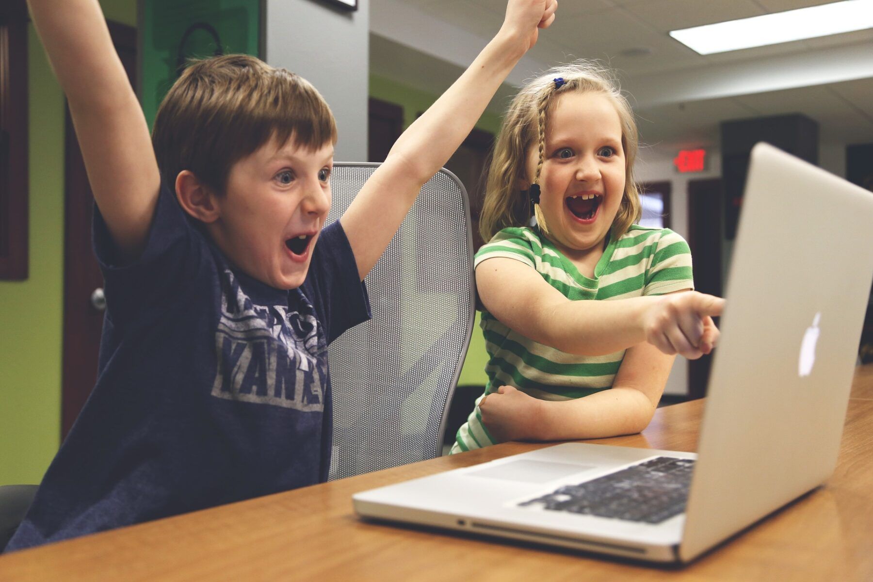Children cheering at a computer screen.