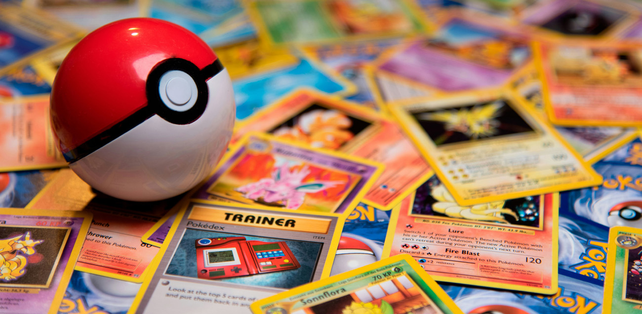 Collection of Pokemon cards next to a Pokemon ball