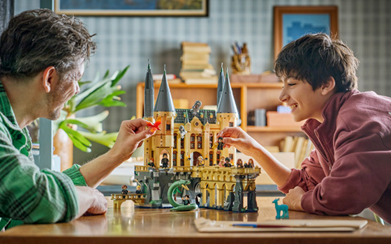 Father and son building a LEGO Harry Potter Hogwarts set
