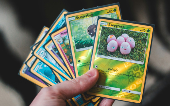 Hand holding a set of Pokemon cards