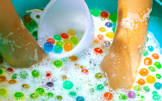 Hands playing with water beads