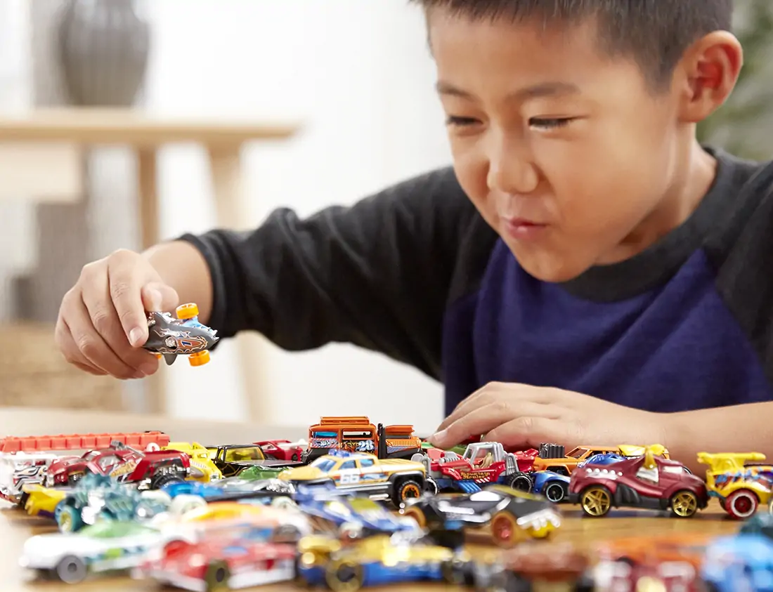 Child plays with Hot Wheels cars..