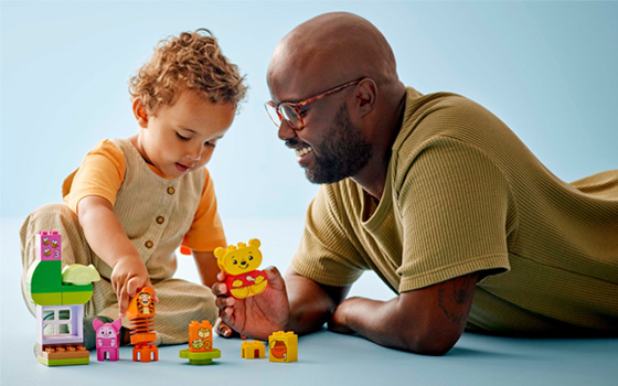 Dad and child building LEGO Duplo