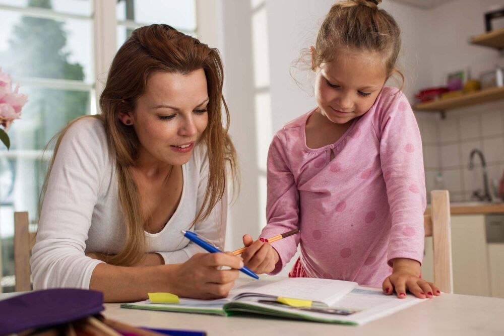 Mother doing homework with child.