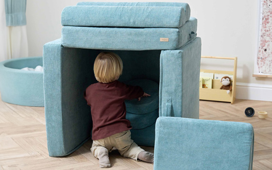 Small boy building a pillow fort