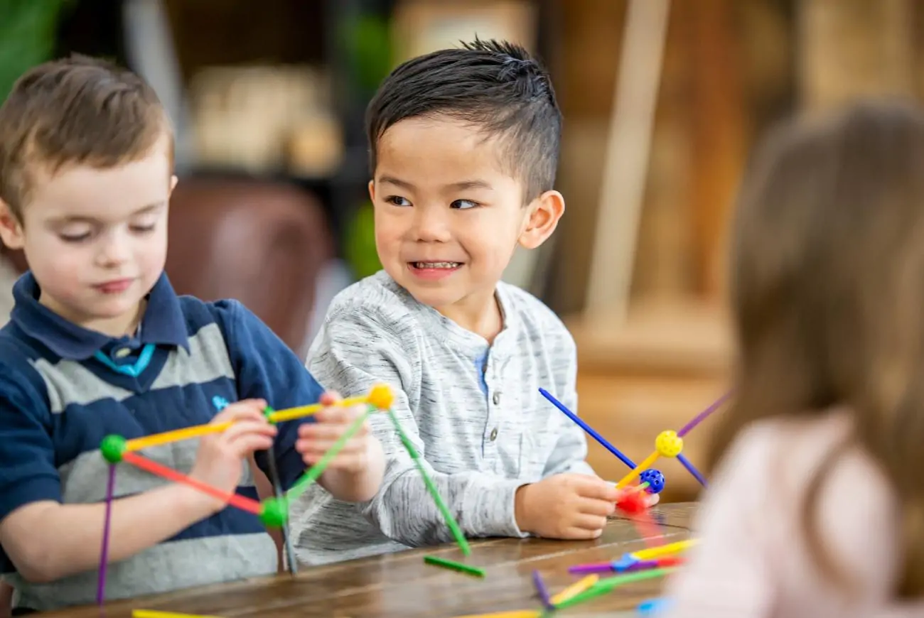 Boy smiles while playing with STEM toys.