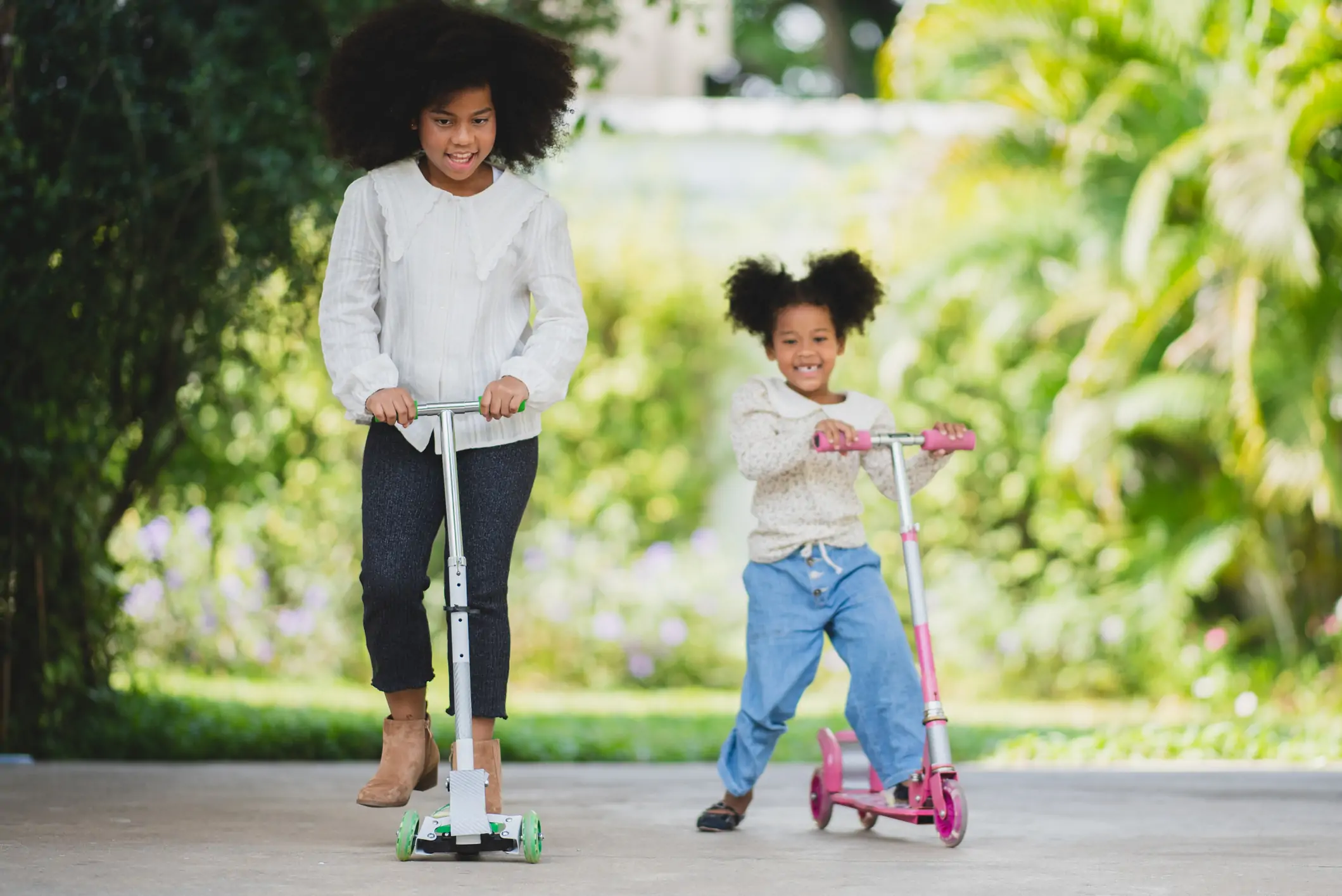 Sisters riding scooters.