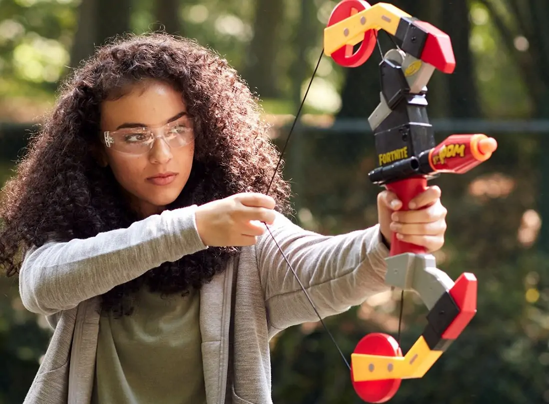 Girl aims with an arrow blaster.