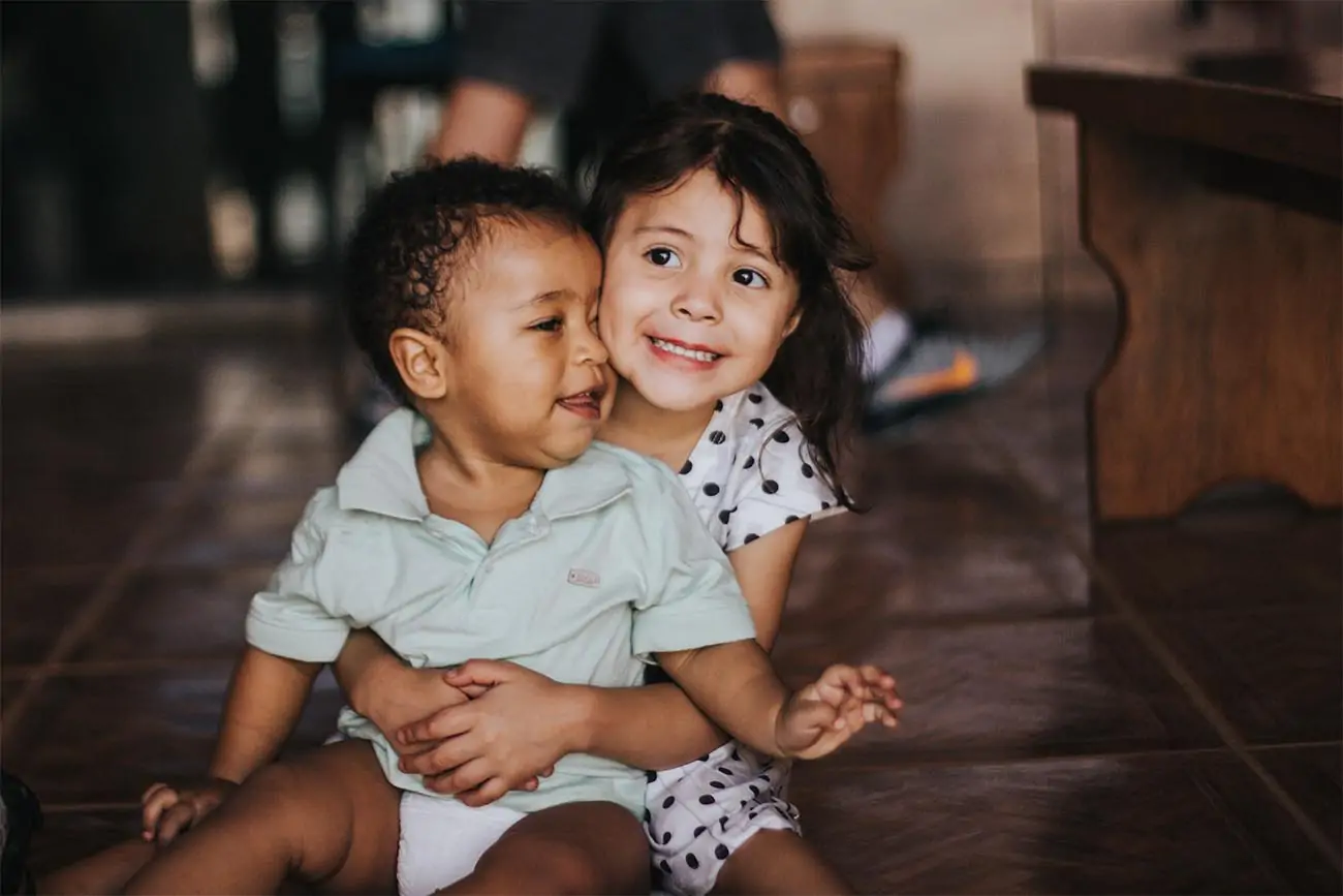 child holding baby on the floor