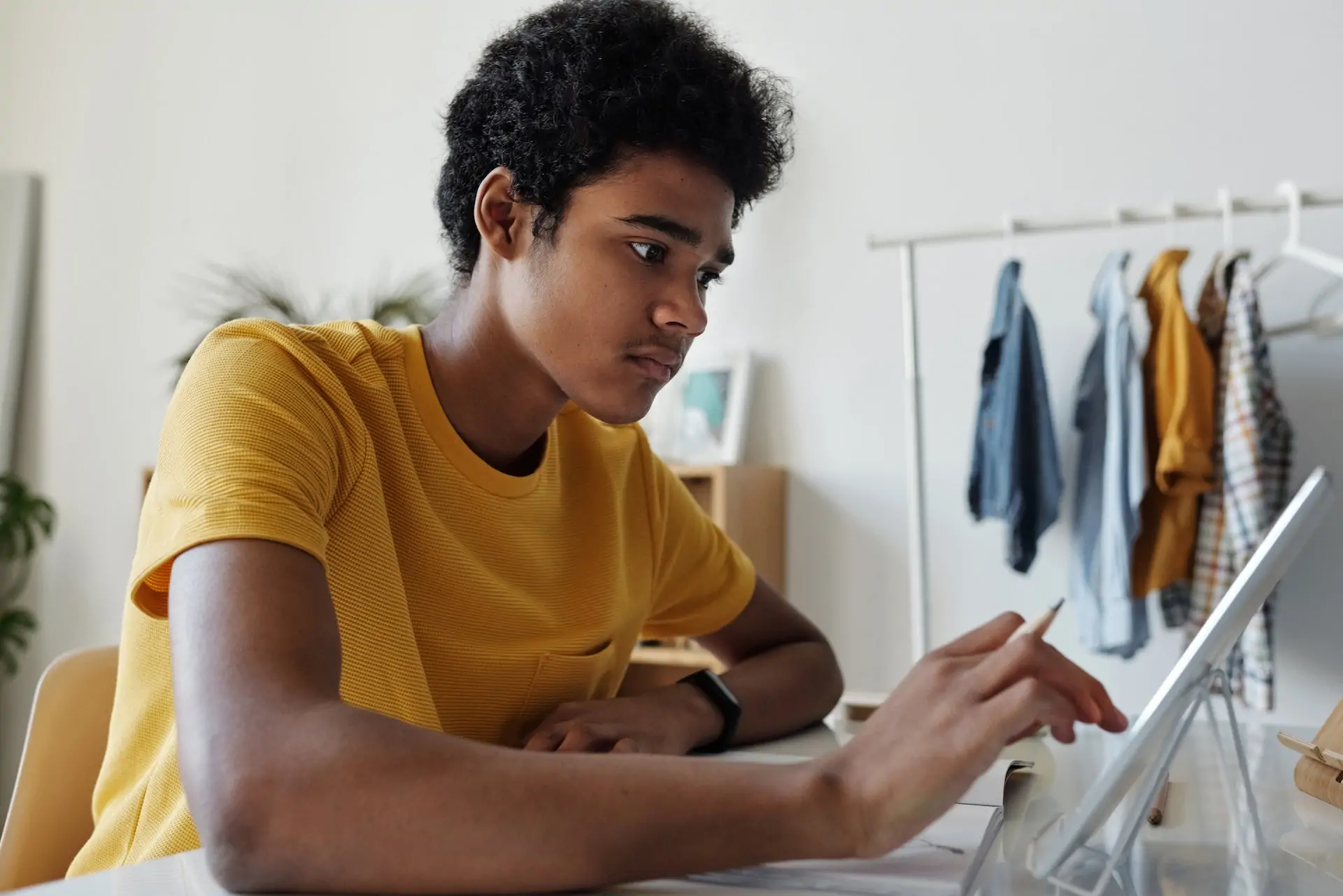 Boy sat on his laptop doing homework.