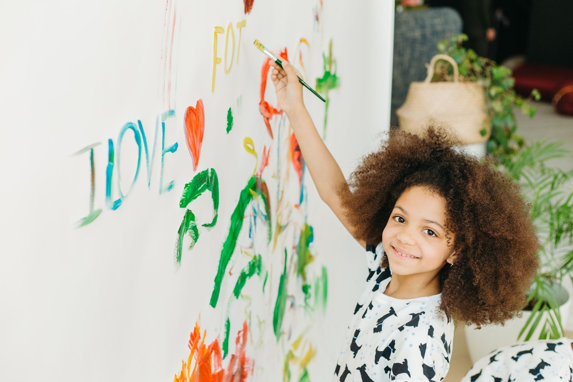 Child paints on the wall.
