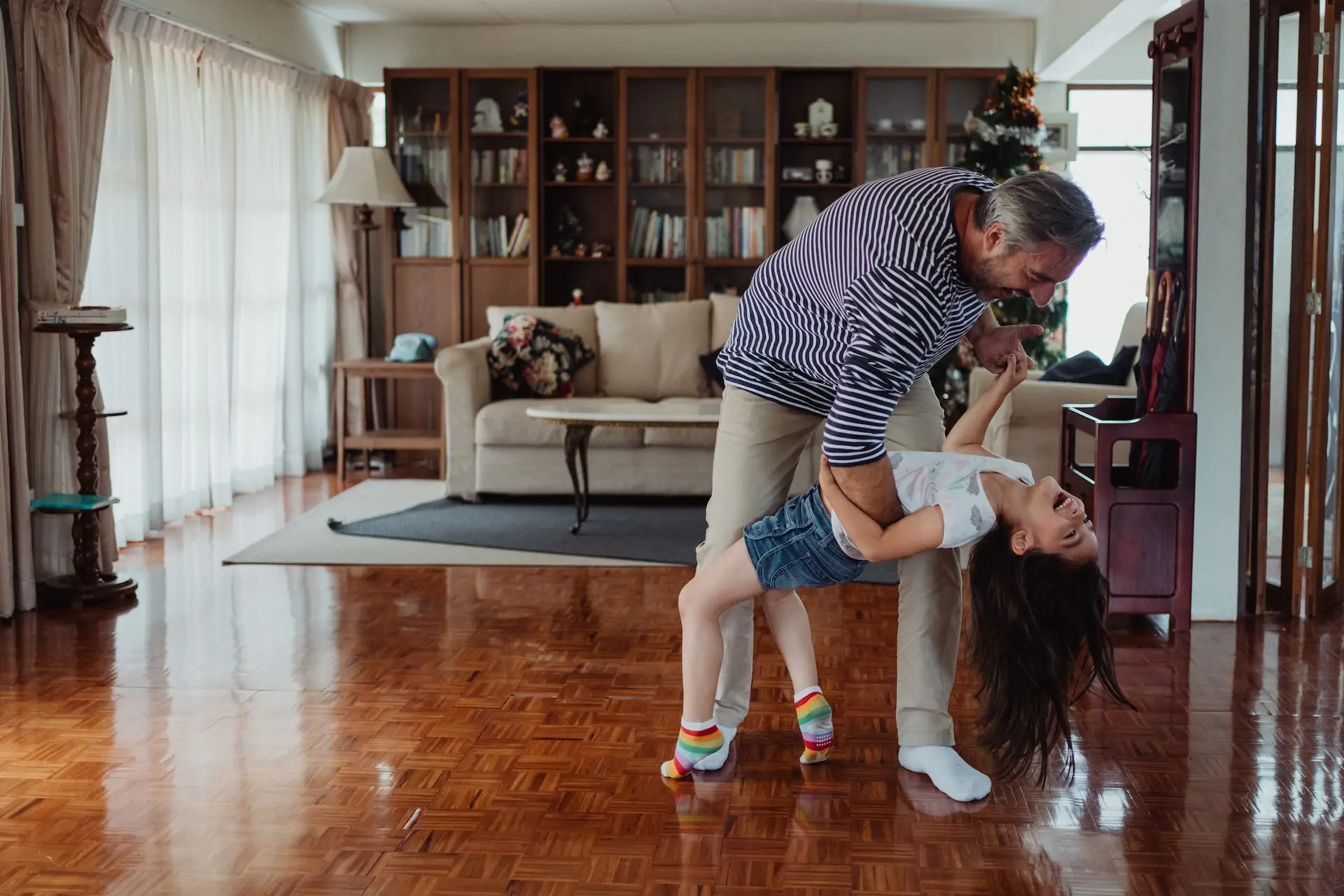 Dad and daughter dance together.