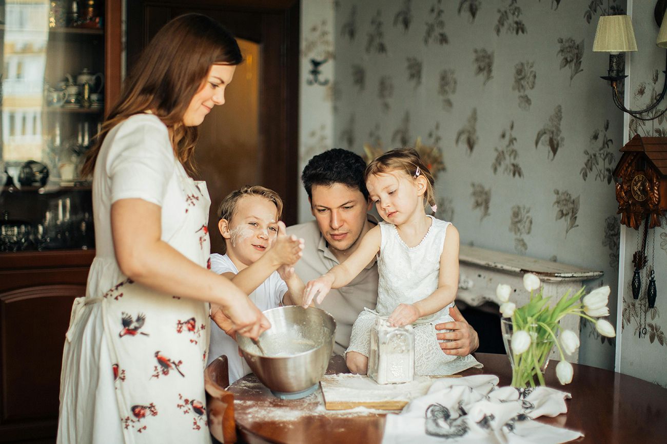 two adults and two children baking together