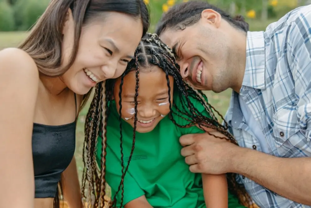 Mum and dad laughing with young child.