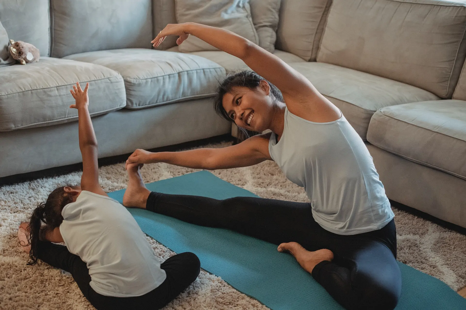 A mother and daughter stretch together.