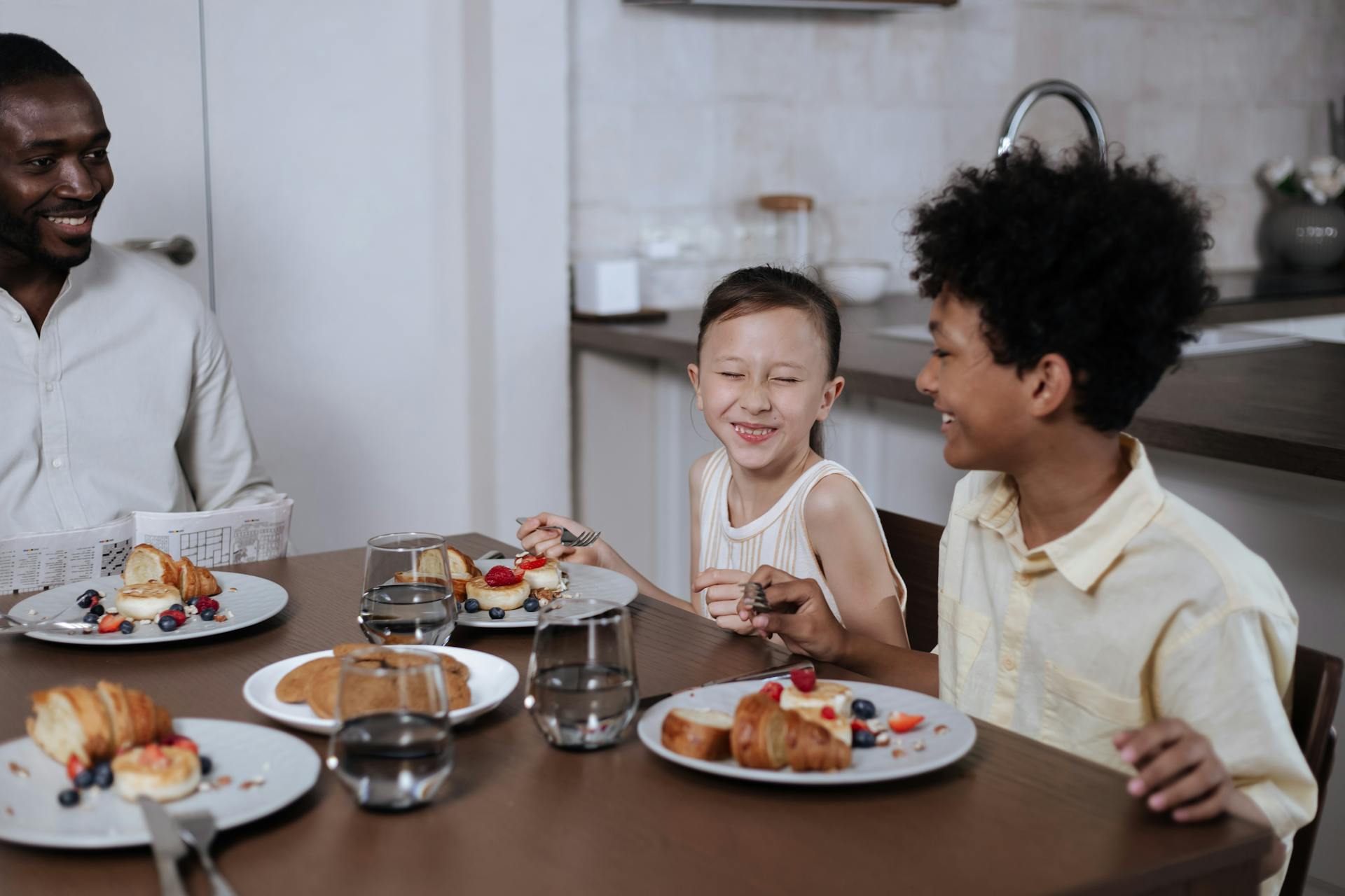 Children have breakfast with dad.