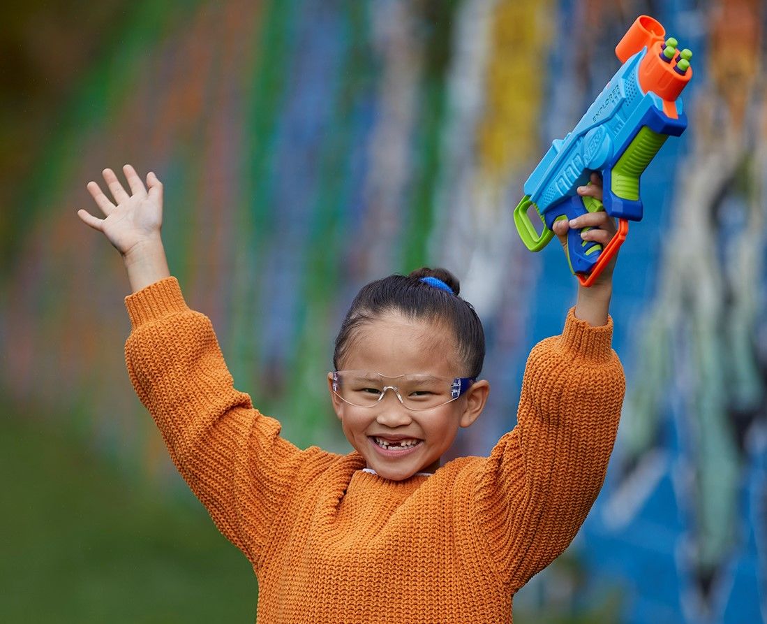 Girl with Nerf Blaster happy.