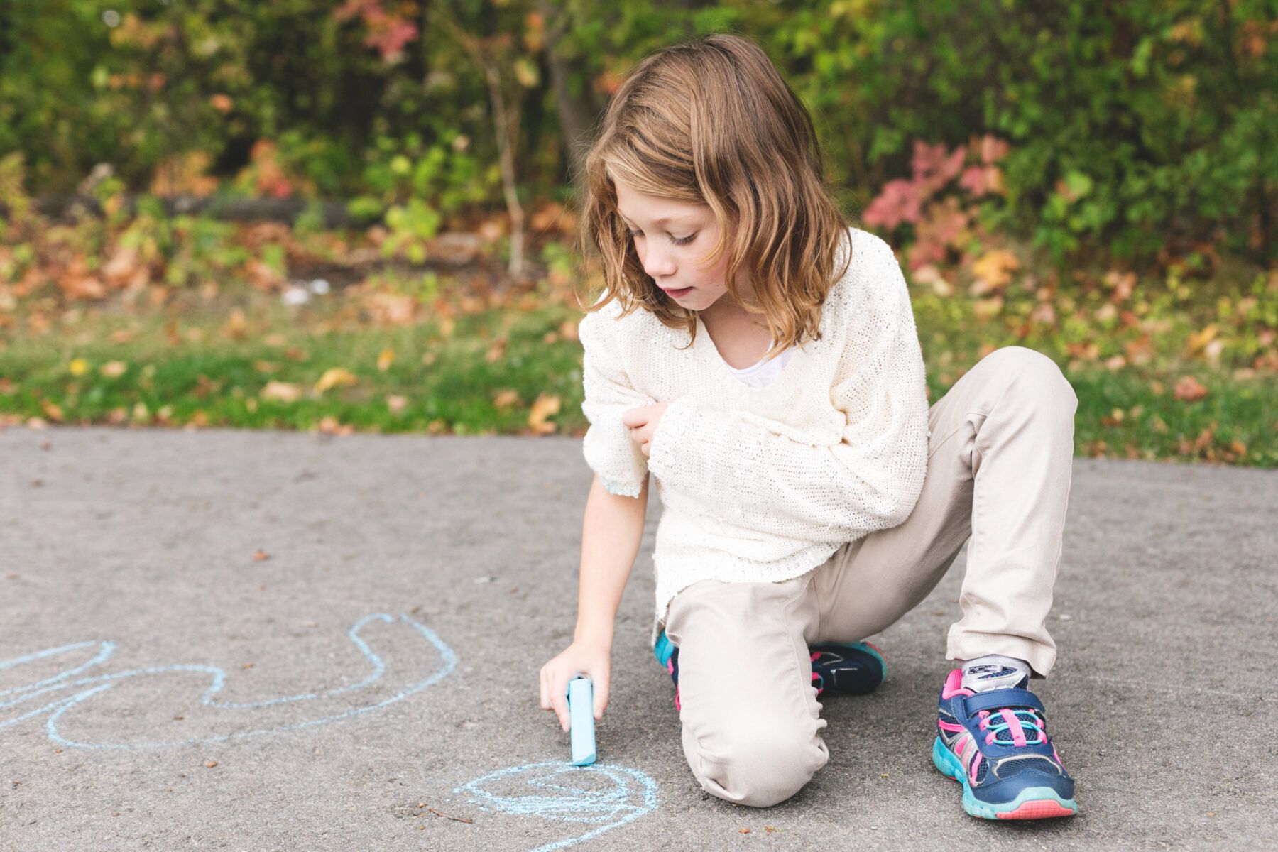 child using chalk on ground
