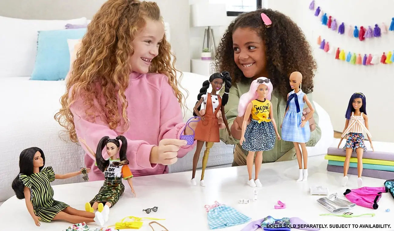 Two girls play with barbies together