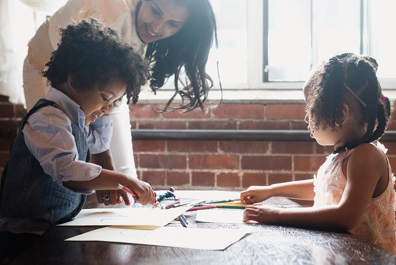 kids colouring with their mum at the table