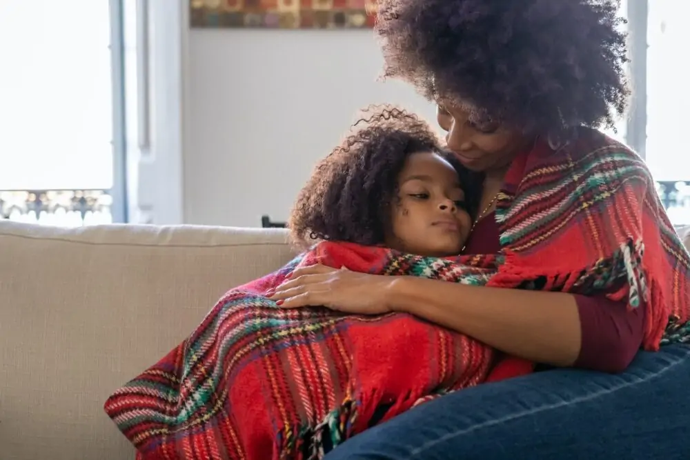 Mum hugging daughter.