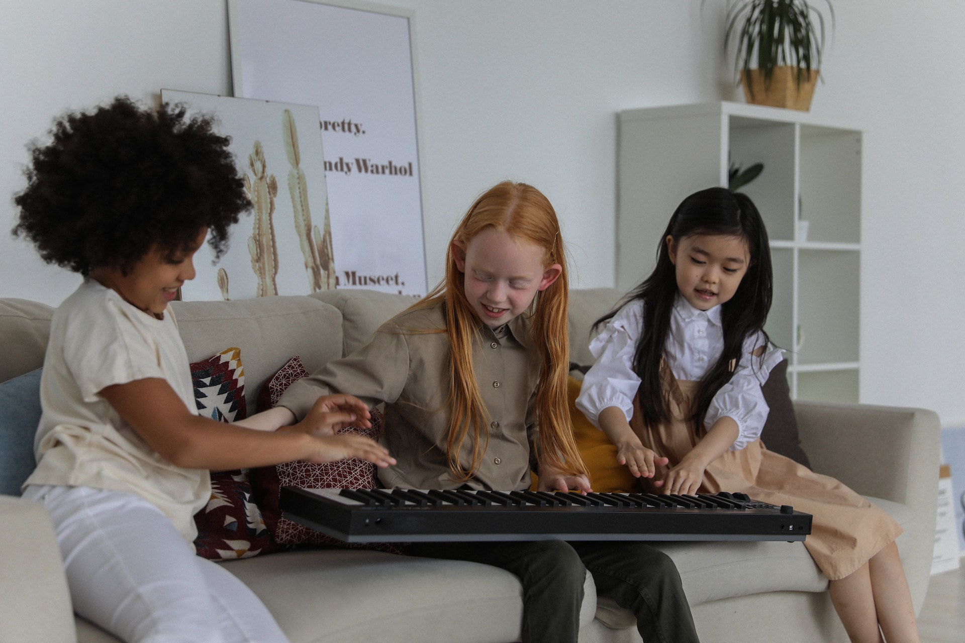 3 kids play with a piano.