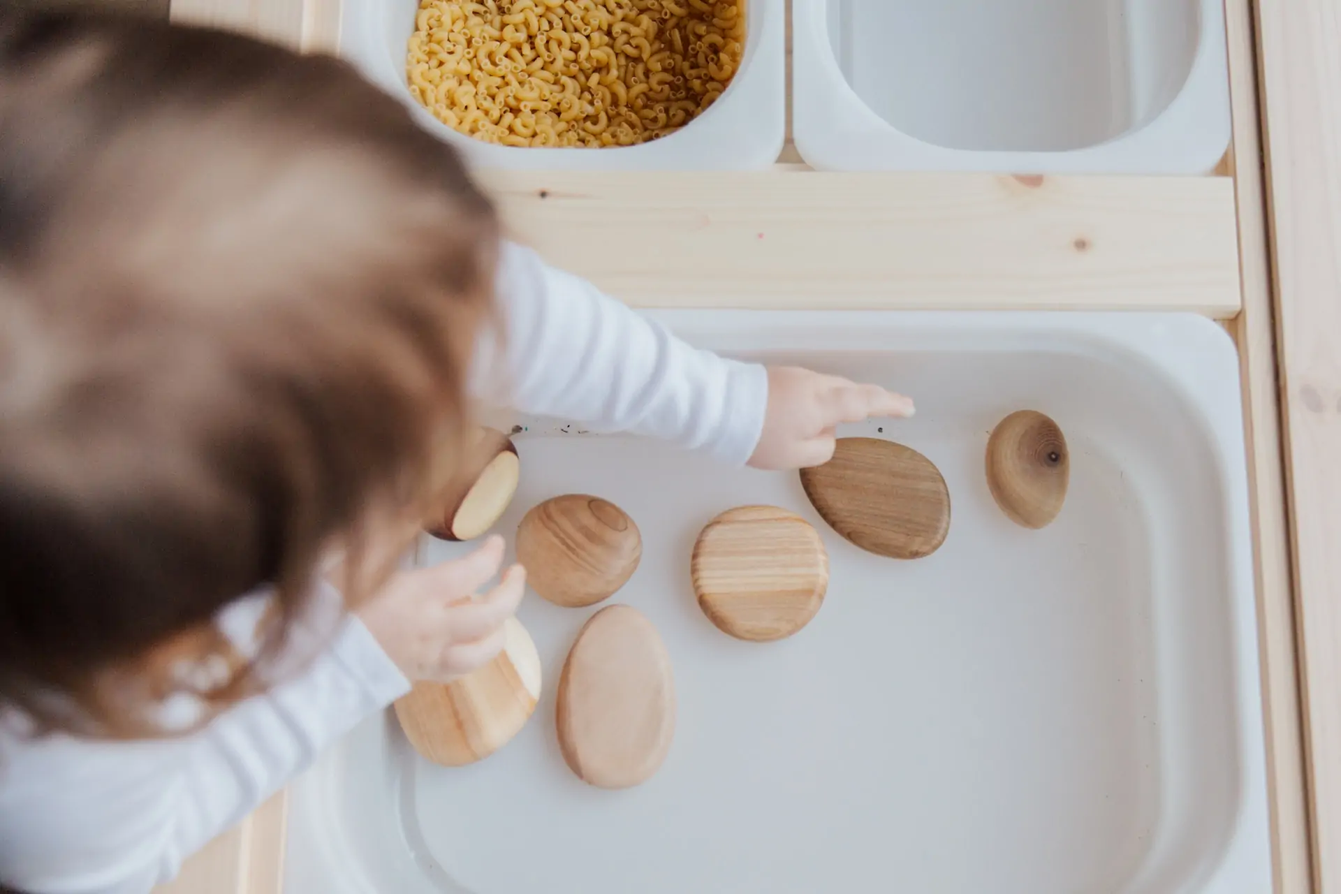 Sensory play with a child picking up smooth rocks.