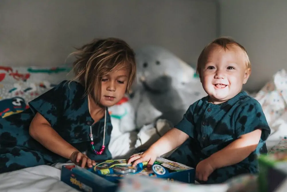 brothers playing a game on the bed in matching pajamas