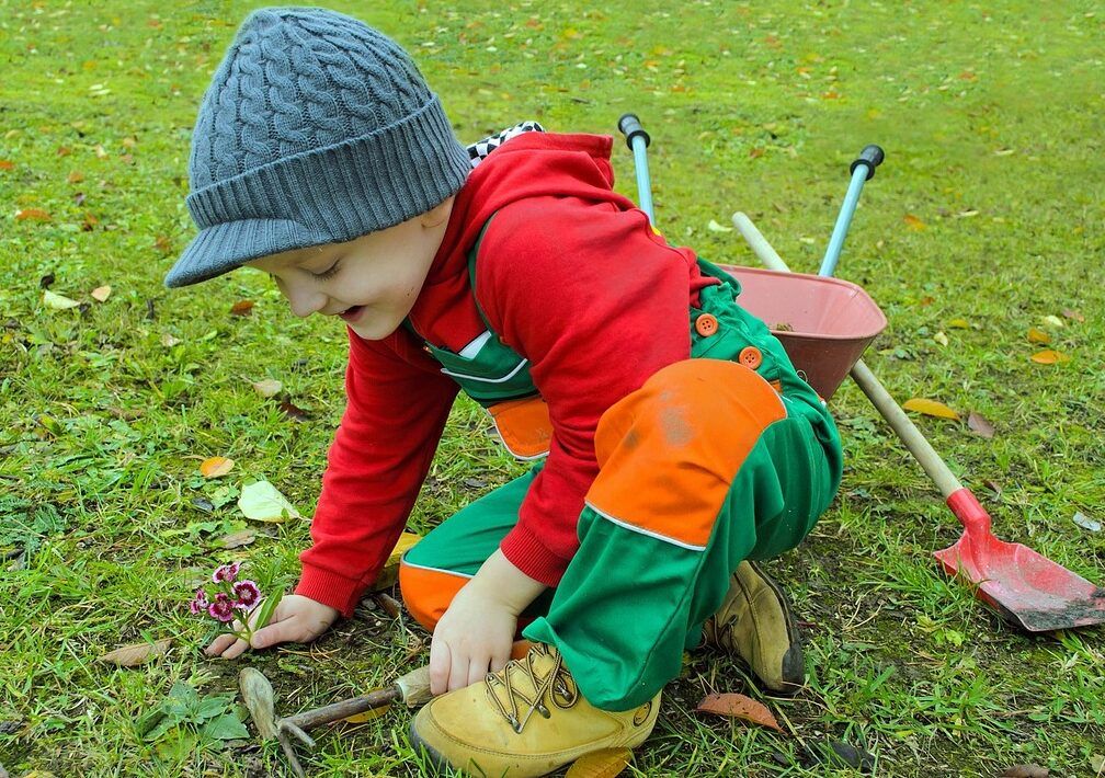 child plays with gardening tools
