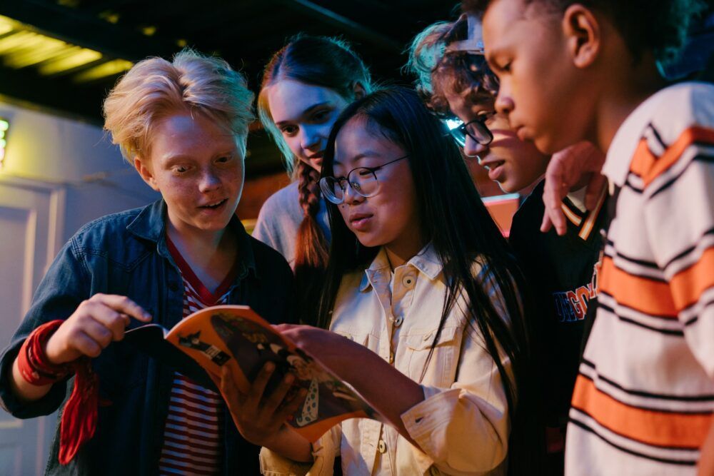 Group of teenagers reading a comic.