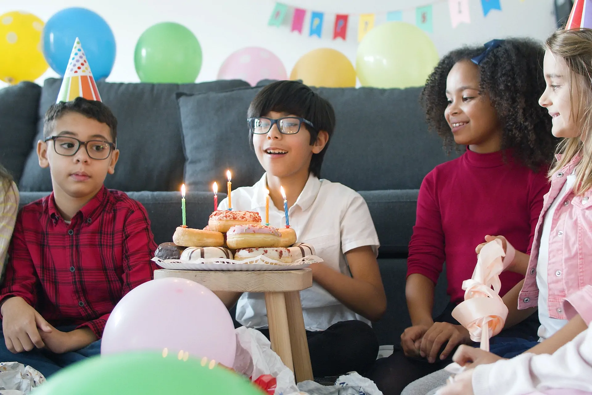 Kids surround friend who's birthday it is.